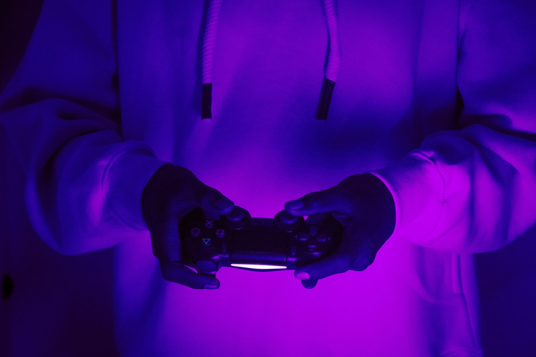 Gamer mit Controller unter Neon-Licht